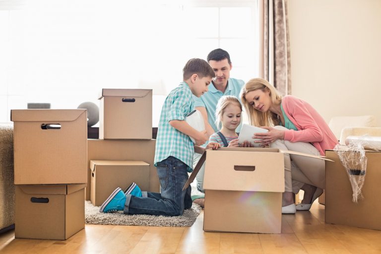 family unpacking moving boxes in their new home