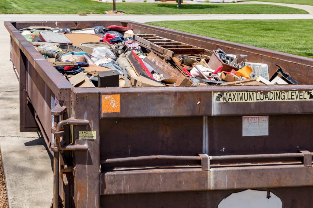 dumpster filled up with junk removal in a neighborhood