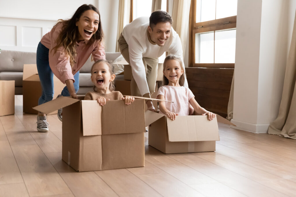 parents with kids moving and playing with the boxes