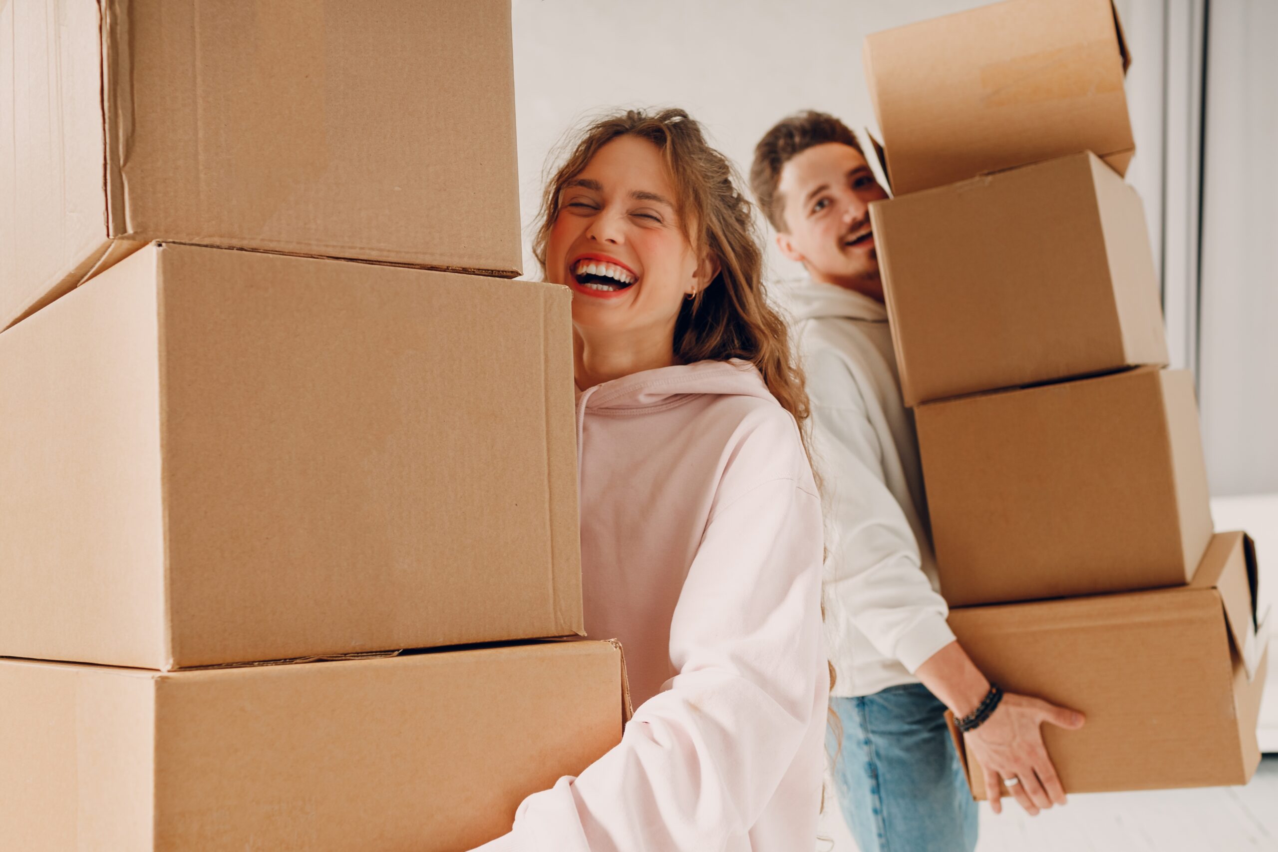 happy couple moving their own boxes during their move
