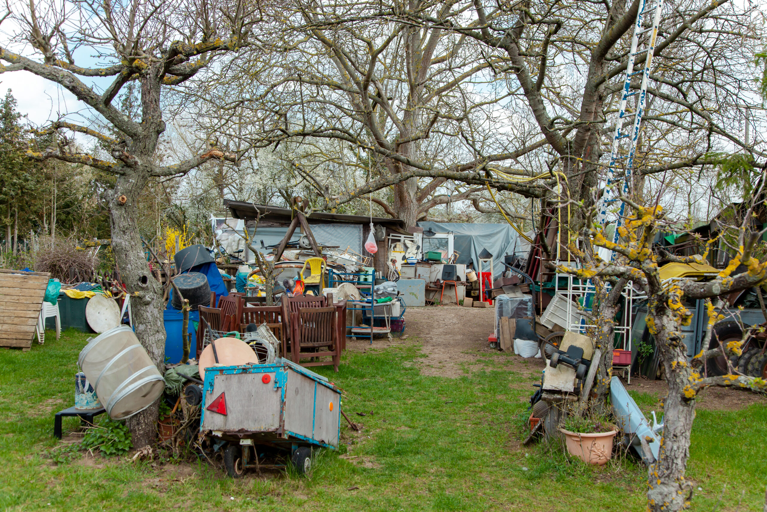 outside view of the front of a hoarder home with lots of junk items around