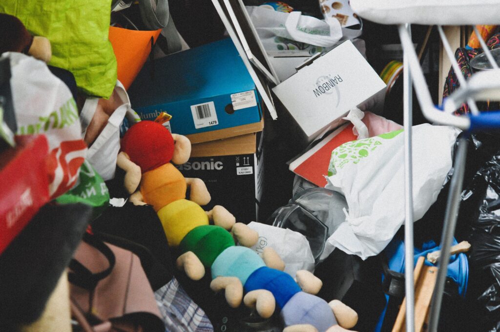 messy garage with piles of toys, boxes, and junk on top of eachother