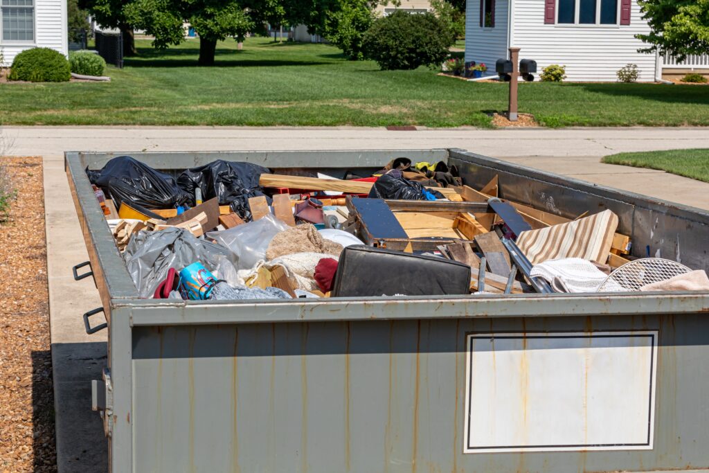 dumpster being used for a home cleanout and is filled with stuff inside